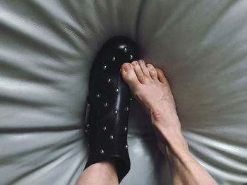 Low section of woman standing on bed