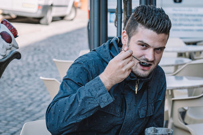 Portrait of young man sitting outdoors