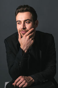 Portrait of young man against gray background