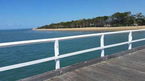 Scenic view of beach against clear blue sky