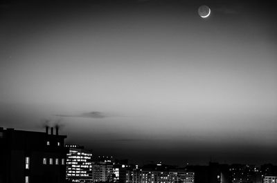 Illuminated cityscape against sky at dusk