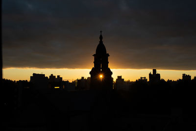 Silhouette of building against sky during sunset