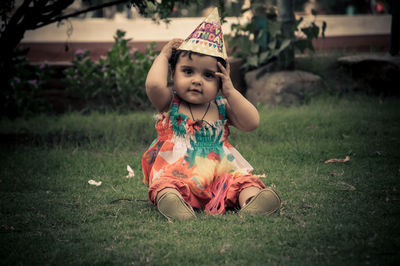 Cute girl sitting on field