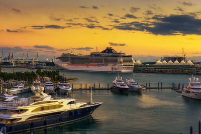 Boats moored at harbor during sunset