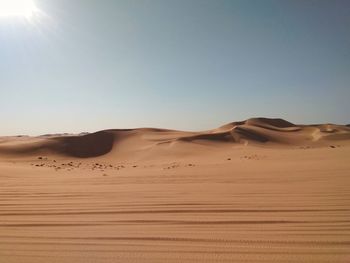 Sand dunes in desert against clear sky