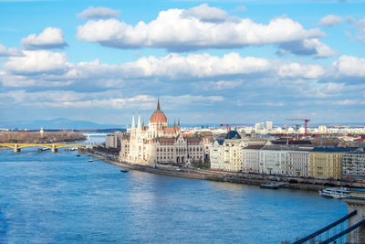 Buildings by sea against sky