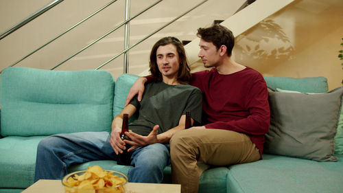 Young couple sitting on sofa at home