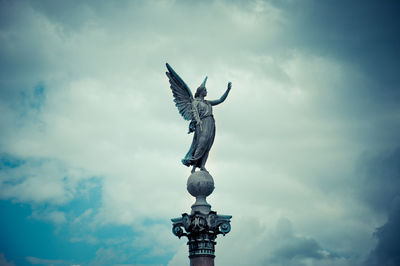 Low angle view of statue of birds flying against sky