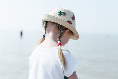 Midsection of woman standing by sea against sky