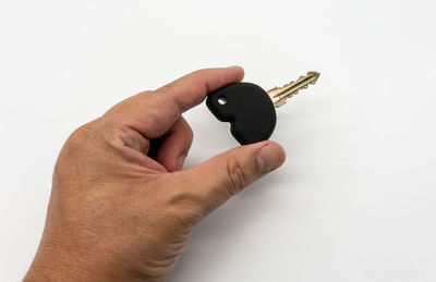 Close-up of man holding hands over white background
