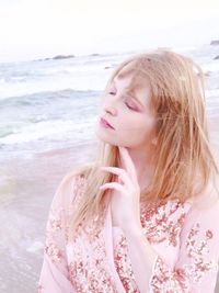 Woman with closed eyes standing at beach