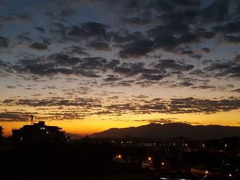 Silhouette cityscape against sky during sunset