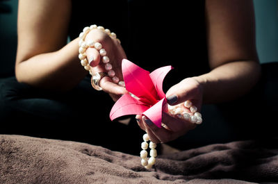 Close-up of hand holding pink flowers