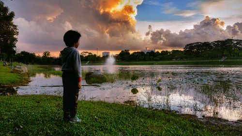 Boy on water against sky