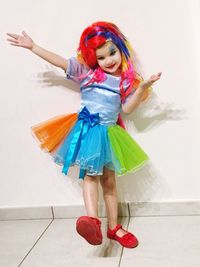 Girl wearing colorful costume dancing on floor