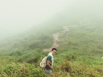 Full length side view of young woman in foggy weather