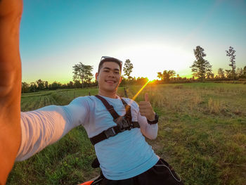 Full length of man standing on field against sky during sunset