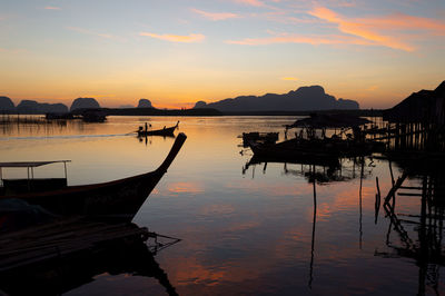 Silhouette sailboats moored in lake against sky during sunset. fishermen village at sunrise.