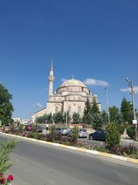 View of road by buildings against sky