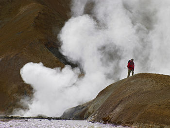 Hiker walking by geothermal vent
