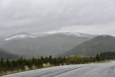 Road by mountains against sky