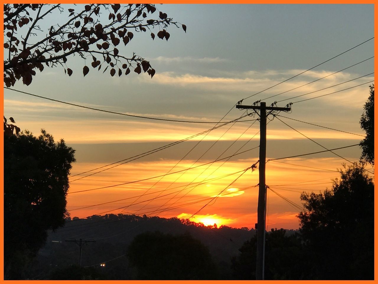 sunset, silhouette, cable, tree, orange color, sky, power line, connection, power supply, nature, beauty in nature, electricity pylon, scenics, no people, electricity, fuel and power generation, tranquil scene, tranquility, outdoors, landscape, low angle view, technology, telephone line, day