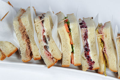 Club sandwich, held together by toothpicks, composed of many tasty ingredients and sauces