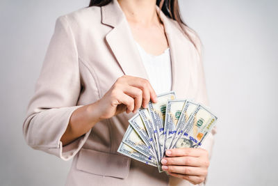 Midsection of woman holding umbrella against white background