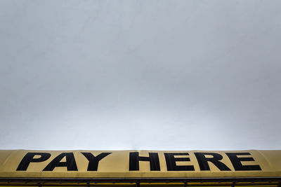 Low angle view of road sign against sky