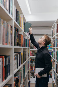 Portrait of young woman standing in library