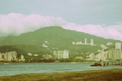 Scenic view of sea by buildings on mountain against sky