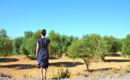 Rear view of woman with umbrella against sky