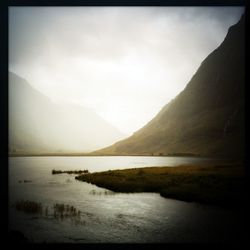 Scenic view of river and mountains against sky