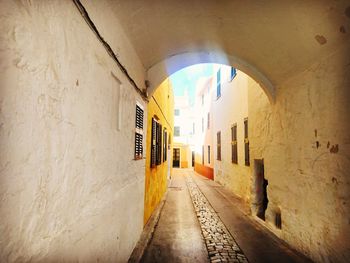 Empty alley amidst buildings in tunnel