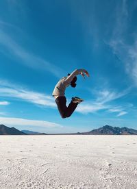 Man jumping against blue sky