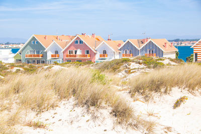 Houses by sea against sky