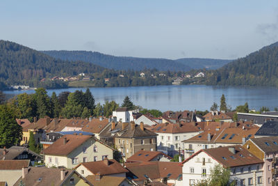 High angle view of townscape by lake against sky