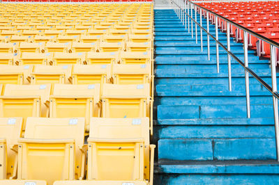 Empty seats in row against yellow wall