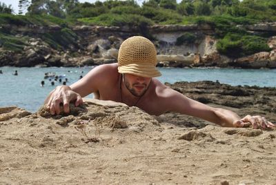 Man lying on sand at beach