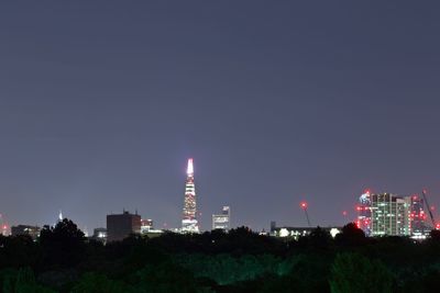 Illuminated buildings against sky at night