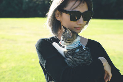 Young woman wearing sunglasses standing on field