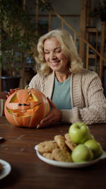 Portrait of young woman holding pumpkin