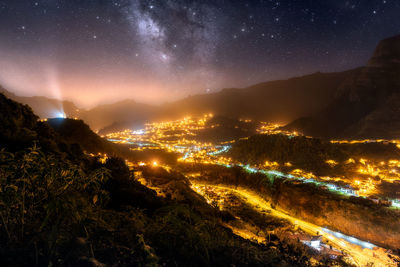 Scenic view of illuminated mountains against sky at night