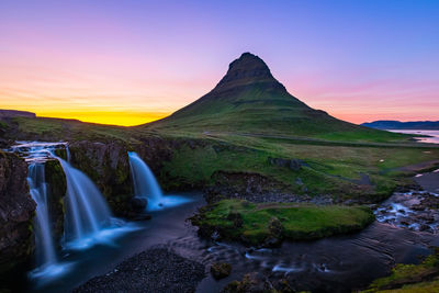 Scenic view of kirkjufell  waterfall and mountain against sky during sunset