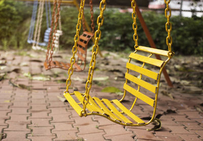 Close-up of yellow swing in park