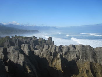 Rock formations in sea against sky