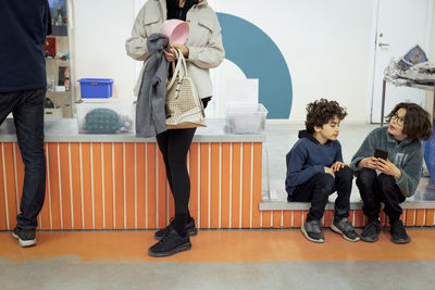 Mother waiting in line with sons at recycling center