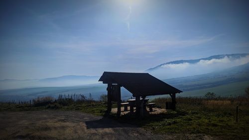 Built structure on land by lake against sky