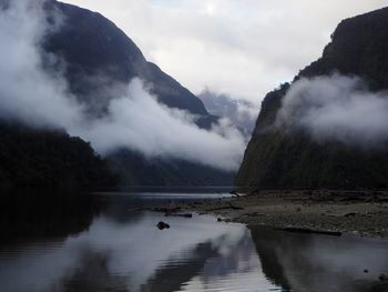 Scenic view of lake by mountains against sky