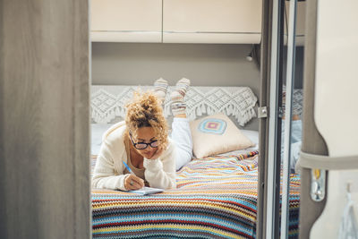 Portrait of woman sitting on bed at home